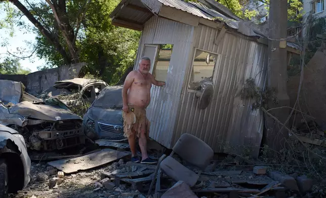 Parking security guard Oleksandr Hnatiuk, 57, smokes a cigarette in front of the booth where he was injured during an overnight Russian missile and drone attack, in Kyiv, Ukraine, Thursday, Aug. 20, 2026. (AP Photo/Francisco Seco)