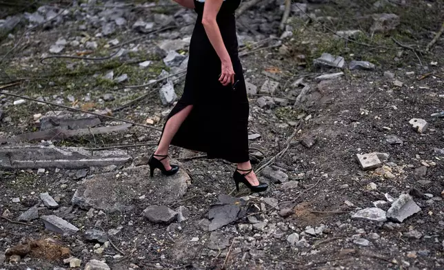 A woman walks across the debris in the aftermath of an overnight Russian missile and drone attack on Kyiv, Ukraine, Thursday, Aug. 20, 2026 (AP Photo/Francisco Seco)