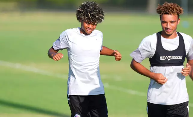 Benji Flowers, left, stretches during a FC Dallas Academy soccer training session in Frisco, Texas, Friday, Aug. 14, 2026. (AP Photo/LM Otero)