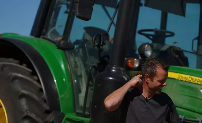 Farmer Maarten Janse stands next to his tractor on a drought stricken wheat field in Wolphaartsdijk, Netherlands, Tuesday, Aug. 11, 2026. (AP Photo/Virginia Mayo)