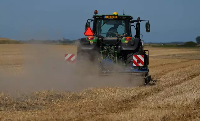 Farmer Maarten Janse drives his tractor on a drought stricken wheat field in Wolphaartsdijk, Netherlands, Tuesday, Aug. 11, 2026. (AP Photo/Virginia Mayo)