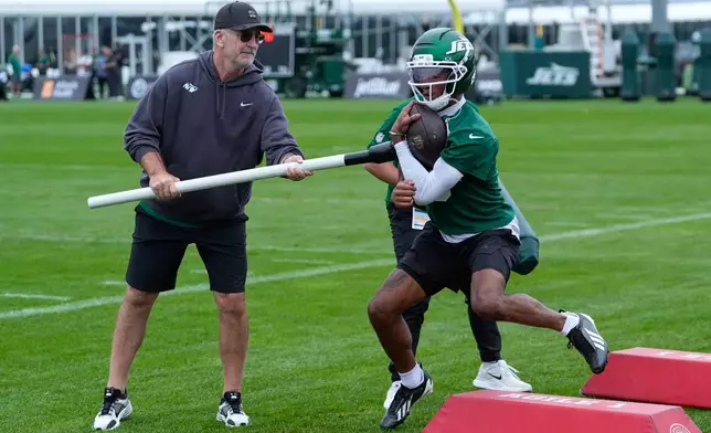 New York Jets' offensive coordinator Frank Reich, left, and Garrett Wilson participate in a drill during practice at the team’s NFL football training camp in Florham Park, N.J., Thursday, July 30, 2026. (AP Photo/Seth Wenig)