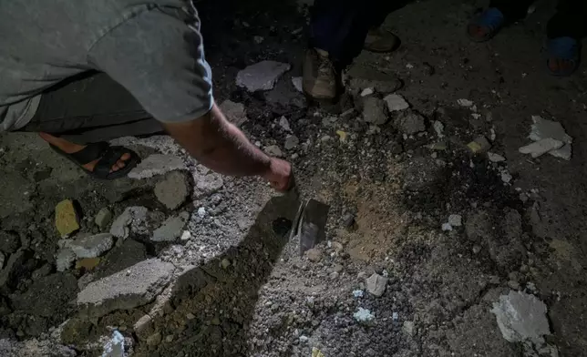 A man examines the impact site of a projectile following a strike in Lamerd, southern Iran, Saturday, Feb. 28, 2026. (Alireza Ameri/Tasnim News Agency via AP)