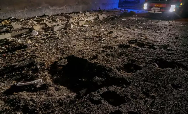 A fire truck's lights reveal a road damaged by a strike in Lamerd, southern Iran, Saturday, Feb. 28, 2026.(Alireza Ameri/Tasnim News Agency via AP)