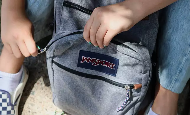 Middle school student Claire Knoth, 13, zips up her backpack after packing it with school supplies Friday, July 31, 2026, in Flagstaff, Ariz. (AP Photo/Cheyanne Mumphrey)