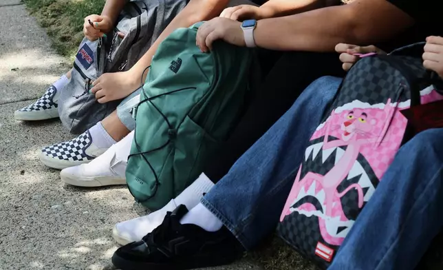 Middle school students Claire Knoth and Brockton Lozano and high school student Zoie Knoth share what is in their backpacks Friday, July 31, 2026, in Flagstaff, Ariz. (AP Photo/Cheyanne Mumphrey)