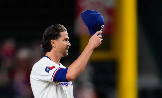 Texas Rangers pitcher Jacob deGrom acknowledges cheers from fans after striking out Washington Nationals' Abimelec Ortiz to earn his 2,000th career strikeout in the first inning of a baseball game Thursday, Aug. 20, 2026, in Arlington, Texas. (AP Photo/Tony Gutierrez)