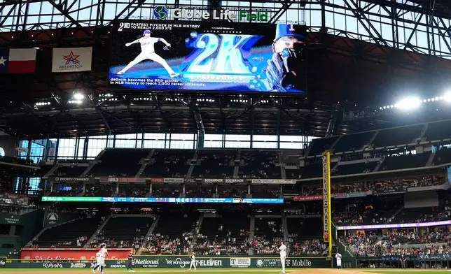 Texas Rangers pitcher Jacob deGrom, center right, stands by the mound after striking out Washington Nationals designated hitter Abimelec Ortiz that gave him his 2,000th career strikeout in the first inning of a baseball game Thursday, Aug. 20, 2026, in Arlington, Texas. (AP Photo/Tony Gutierrez)
