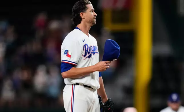 Texas Rangers pitcher Jacob deGrom acknowledges cheers from fans after striking out Washington Nationals' Abimelec Ortiz to earn his 2,000th career strikeout in the first inning of a baseball game Thursday, Aug. 20, 2026, in Arlington, Texas. (AP Photo/Tony Gutierrez)