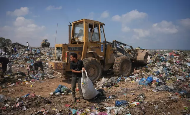 Palestinians search through a garbage dump for combustible materials to use as fuel for cooking due to a shortage of cooking gas, in Deir al-Balah, central Gaza Strip, Saturday, Aug. 22, 2026. (AP Photo/Abdel Kareem Hana)