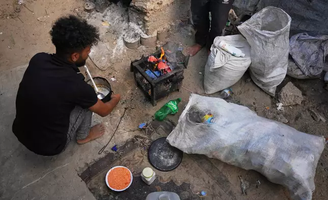 Palestinians use combustible materials collected from a garbage dump as fuel for cooking amid a shortage of cooking gas in Deir al-Balah, central Gaza Strip, Saturday, Aug. 22, 2026. (AP Photo/Abdel Kareem Hana)