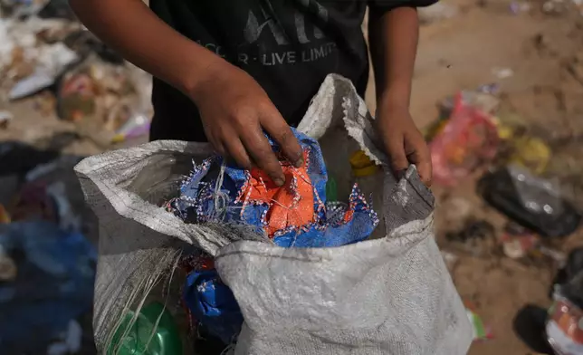 Palestinians search through a garbage dump for combustible materials to use as fuel for cooking due to a shortage of cooking gas, in Deir al-Balah, central Gaza Strip, Saturday, Aug. 22, 2026. (AP Photo/Abdel Kareem Hana)