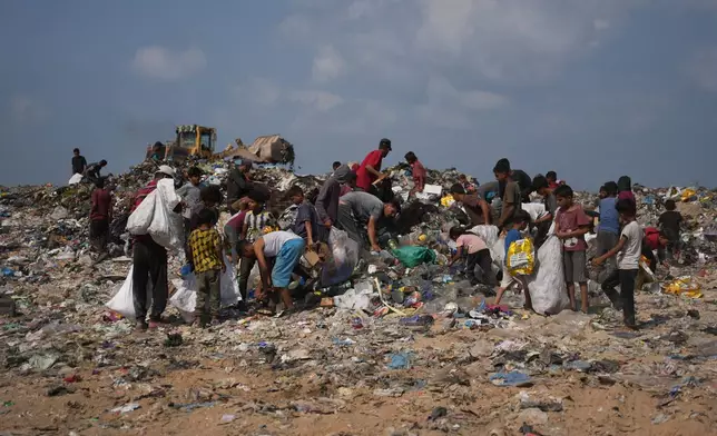 Palestinians search through a garbage dump for combustible materials to use as fuel for cooking due to a shortage of cooking gas, in Deir al-Balah, central Gaza Strip, Saturday, Aug. 22, 2026. (AP Photo/Abdel Kareem Hana)