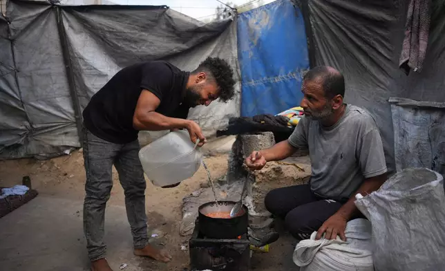 Palestinians use combustible materials collected from a garbage dump as fuel for cooking amid a shortage of cooking gas in Deir al-Balah, central Gaza Strip, Saturday, Aug. 22, 2026. (AP Photo/Abdel Kareem Hana)