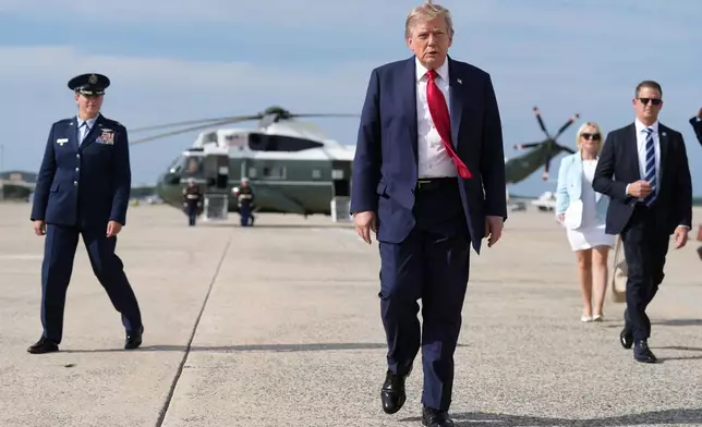 FILE - President Donald Trump, center, walks from Marine One to board Air Force One, Aug. 21, 2026, at Joint Base Andrews, Md., en route to South Carolina. (AP Photo/Jacquelyn Martin, File)