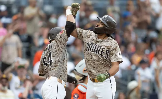 San Diego Padres' Fernando Tatis Jr., right, celebrates with teammate Freddy Fermin at home plate after hitting a home run during the fourth inning of a baseball game against the Houston Astros, Sunday, Aug. 9, 2026, in San Diego. (AP Photo/Karl Anderson)