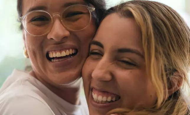 Newlyweds Scarlett Rocha, right, and Fabiana Justiniano pose for a photo at their home in Santa Cruz, Bolivia, Saturday, Aug. 15, 2026. (AP Photo/Juan Karita)