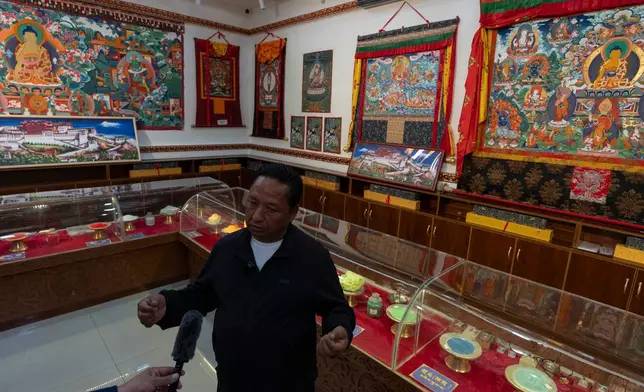 Pasang, founder of the Ethnic Huaji Handwoven Cooperative, is interviewed in a showroom of the products in Shannan in western China's Tibet Autonomous Region on July 23, 2026, as seen during a government organized visit for foreign journalists. (AP Photo/Ng Han Guan)