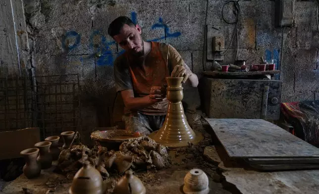 Ahmed Fakhoury, 27, uses a pottery wheel to make clay pots at a traditional pottery workshop in the West Bank city of Hebron, Wednesday, Aug. 26, 2026. (AP Photo/Mahmoud Illean)