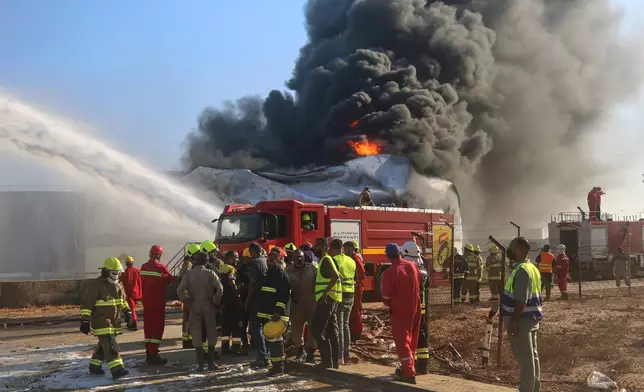 Firefighters work to contain a fire at the Zawiya oil refinery following a drone strike in Zawiya, Libya, Tuesday, Aug. 11, 2026. (AP Photo/Yousef Murad)