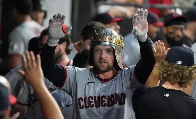 Cleveland Guardians' Rhys Hoskins is greeted in the dugout after hitting a two-run home run against the Chicago White Sox during the sixth inningof a baseball game Saturday, Aug 8, 2026, in Chicago. (AP Photo/David Banks)