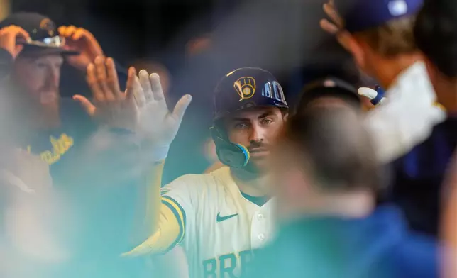 Milwaukee Brewers' Garrett Mitchell high-fives teammates after hitting a home run during the eighth inning of a baseball game against the Seattle Mariners Thursday, Aug. 20, 2026, in Milwaukee. (AP Photo/Kayla Wolf)