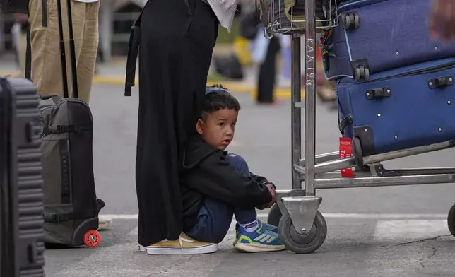 A child sits on the floor as passengers wait for delayed flights during a workers strike at Jomo Kenyatta International Airport in Nairobi, Kenya, Monday, Aug. 31, 2026. (AP Photo/Brian Inganga)