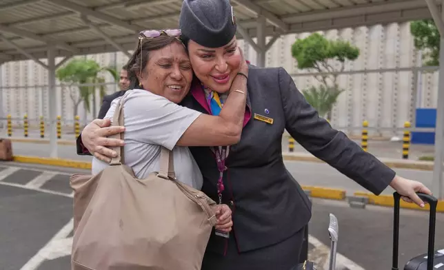 A passenger hugs a Qatar Airways flight attendant after a delayed flight was cleared for departure during a workers strike at Jomo Kenyatta International Airport, in Nairobi, Kenya, Monday, Aug. 31, 2026. (AP Photo/Brian Inganga)