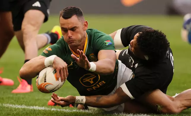 South Africa's Jesse Kriel, left, scores a try as New Zealand's captain Ardie Savea tries to defend during a second Test rugby match between South Africa and New Zealand, in Cape Town, South Africa, Saturday, Aug. 29, 2026. (AP Photo/Halden Krog)