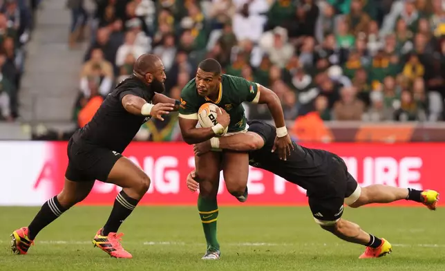 South Africa's Damian Willemse, center, is being tackled by New Zealand's Luke Jacobson, right, and his teammate George Bower during a second Test rugby match between South Africa and New Zealand, in Cape Town, South Africa, Saturday, Aug. 29, 2026. (AP Photo/Halden Krog)