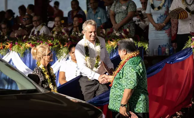 FILE - Prime Minister Tuilaepa Sailele Malielegaoi, foreground right, shakes hands with Robert F. Kennedy Jr. at the the 57th Independence Celebration in Mulinu'u, Samoa, June 1, 2019. At foreground left is Kennedy's wife, actress Cheryl Hines.(Misiona Simo/Samoa Observer via AP, File)