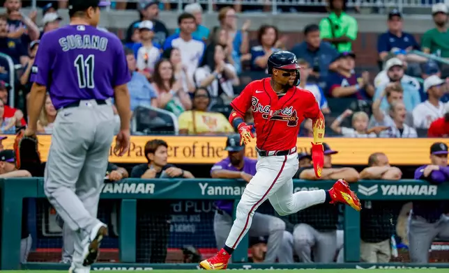 Atlanta Braves' Ronald Acuña Jr., right, on a double by Michael Harris II as Colorado Rockies pitcher Tomoyuki Sugano (11) looks on during the second inning of a baseball game, Friday, Aug. 28, 2026, in Atlanta. (AP Photo/Erik S. Lesser)