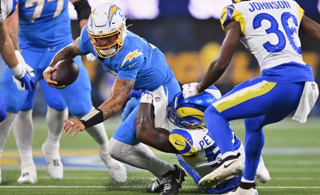 Los Angeles Chargers quarterback Trey Lance, above, is brought down by Los Angeles Rams linebacker Darryl Peterson III for a sack during the first half of an NFL preseason football game Thursday, Aug. 27, 2026, in Inglewood, Calif. (AP Photo/Katie Chin)