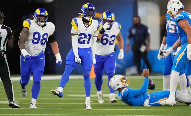 Los Angeles Rams cornerback Cam Lampkin (21) celebrates after bringing down Los Angeles Chargers quarterback DJ Uiagalelei, below, during the first half of an NFL preseason football game Thursday, Aug. 27, 2026, in Inglewood, Calif. (AP Photo/Mark J. Terrill)