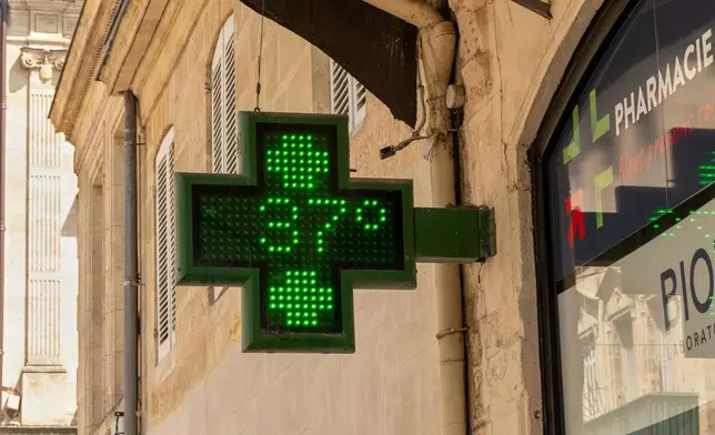 A pharmacy sign displays a temperature of 37 degrees Celsius (98.6 degrees Fahrenheit) in Bordeaux, France, Thursday, Aug. 13, 2026, as a heatwave affects much of the country. (AP Photo/Caroline Blumberg)