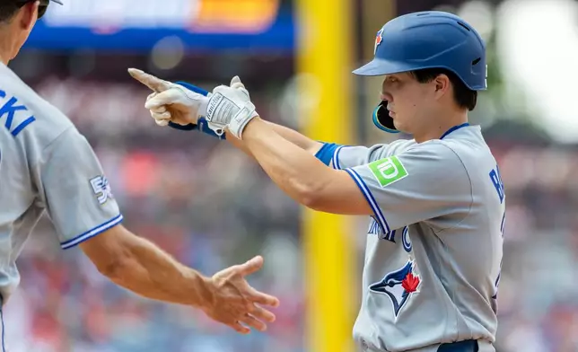 Toronto Blue Jays' Brett Bateman, right, gestures from first base after hitting an RBI single during the fifth inning of a baseball game against the Philadelphia Phillies, Sunday, Aug. 9, 2026, in Philadelphia. (AP Photo/Laurence Kesterson)