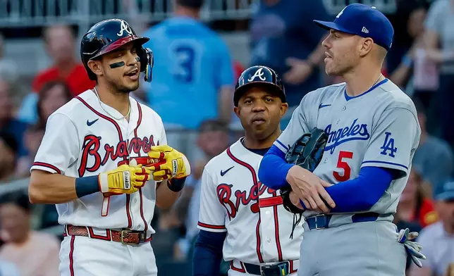 Atlanta Braves' Mauricio Dubón, left, reacts with Los Angeles Dodgers first baseman Freddie Freeman (5), after Dubón hit an RBI single during the first inning of a baseball game, Tuesday, August 25, 2026, in Atlanta. (AP Photo/Erik S. Lesser)