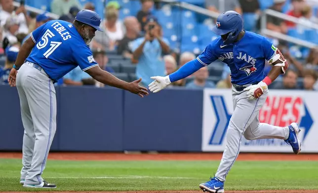 Toronto Blue Jays' Daz Cameron celebratees his home run off Tampa Bay Rays pitcher Ian Seymour with third base coach Carlos Febles (51) during the fifth inning of a baseball game Thursday, Aug. 20, 2026, in St. Petersburg, Fla. (AP Photo/Chris O'Meara)