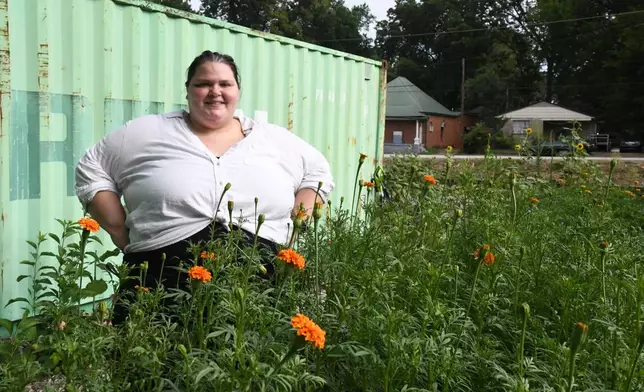Marisa Mender-Franklin poses for a picture on Thursday, July 23, 2026, in one of the properties that she crowdsourced for free to plant flowers for her florist shop in Memphis, Tenn. (AP Photo/Kristin M. Hall)