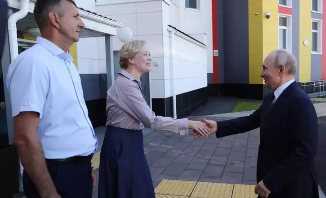 Russian President Vladimir Putin, right, visits the Secondary School named after the Hero of Russia Eduard Norpolov in Kurilsk on the Iturup Island, the largest of the Kuril Islands of Russia's fareast, on Thursday, Aug. 13, 2026. (Gavriil Grigorov, Sputnik, Kremlin Pool Photo via AP)
