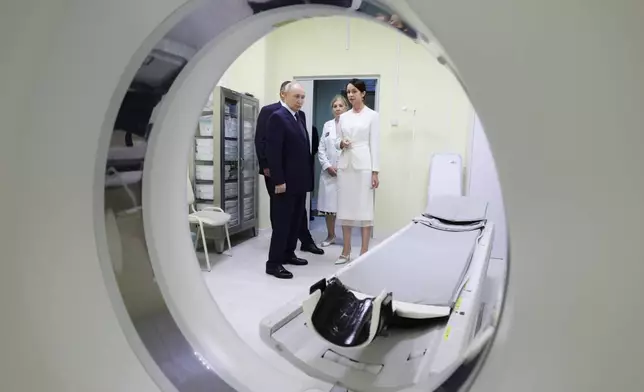 Russian President Vladimir Putin, left, visits the central district hospital at Kitovoye village on the Iturup Island, the largest of the Kuril Islands of Russia's fareast, on Thursday, Aug. 13, 2026. (Gavriil Grigorov, Sputnik, Kremlin Pool Photo via AP)