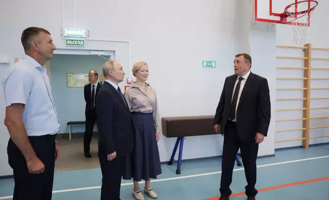 Russian President Vladimir Putin, second left, visits a secondary school named after Eduard Norpolov in Kurilsk on the Iturup Island, the largest of the Kuril Islands of Russia's far-east, on Thursday, Aug. 13, 2026. (Gavriil Grigorov, Sputnik, Kremlin Pool Photo via AP)