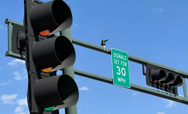 A sign notifies drivers that stoplights are set for a specific speed limit as part of the "rest on red" signal program in Albuquerque, N.M., Wednesday, Aug. 12, 2026. (AP Photo/Susan Montoya Bryan)