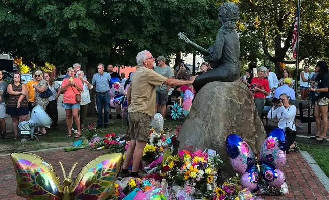 James A. Gambrell, a former chef at Dollywood, touches the Dolly Parton statue in downtown Sevierville, Tenn., on Tuesday, Aug. 25, 2026. (AP Photo/Dylan Lovan)