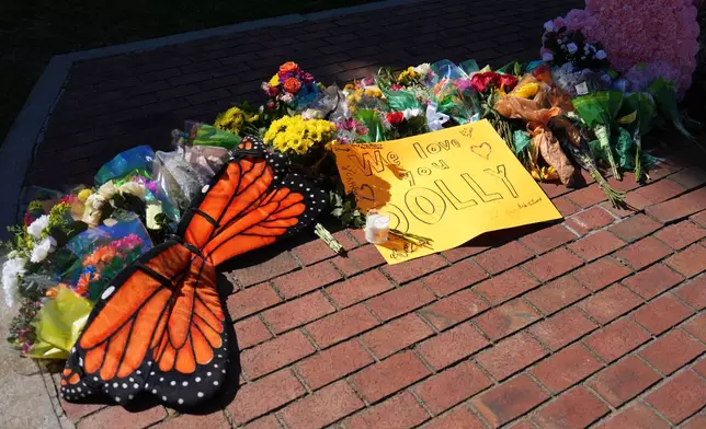 Flowers and monarch butterfly wings form part of a makeshift memorial honoring Dolly Parton in Sevierville, Tenn., Tuesday, Aug. 25, 2026. (AP Photo/Camden Hall)