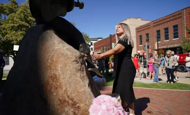 A woman stands before a statue of Dolly Parton in Sevierville, Tenn., Tuesday, Aug. 25, 2026. (AP Photo/Camden Hall)