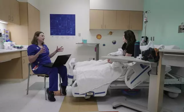 Dr. Melanie Cree explains medical results to Noelani Schulmeister in a study using GLP-1 medication to treat PMOS Friday, July 10, 2026 in Aurora, Colo. (AP Photo/Brittany Peterson)