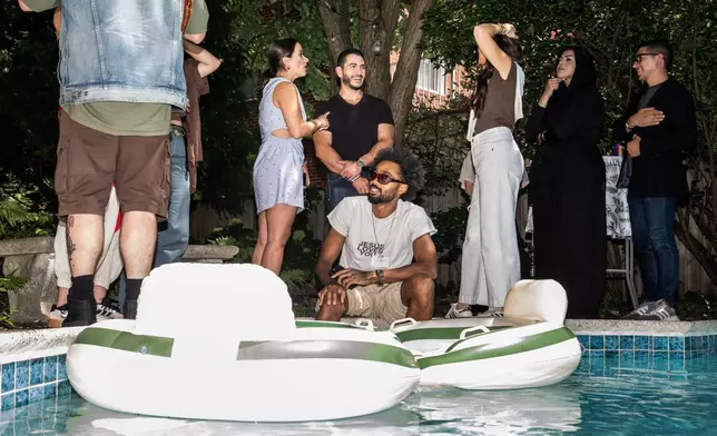 Abdul El-Sayed, a progressive candidate in the Democratic primary for U.S. Senate in Michigan, talks poolside at a party for content creators supporting his campaign, Monday, Aug. 3, 2026, in Detroit. (AP Photo/Julia Demaree Nikhinson)
