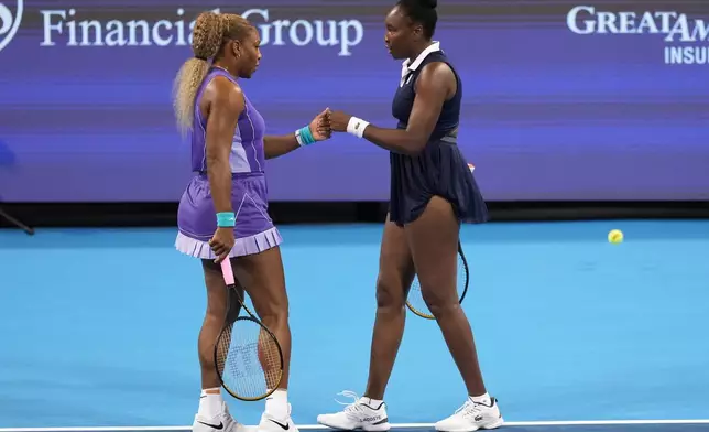 Serena Williams, left, first bumps Venus Williams, right, both of the United States, during a women's doubles match against Marta Kostyuk, of Ukraine, and Peyton Stearns, also of the United States, at the Cincinnati Open tennis tournament, Monday, Aug. 17, 2026, in Mason, Ohio. (AP Photo/Kareem Elgazzar)