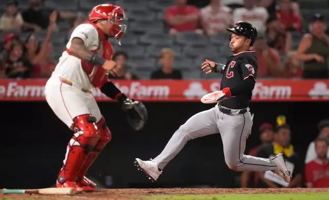 Cleveland Guardians' Steven Kwan, right, scores on a double by José Ramírez as Los Angeles Angels catcher Moisés Ballesteros stands at the plate during the 10th inning of a baseball game Tuesday, Aug. 25, 2026, in Anaheim, Calif. (AP Photo/Mark J. Terrill)